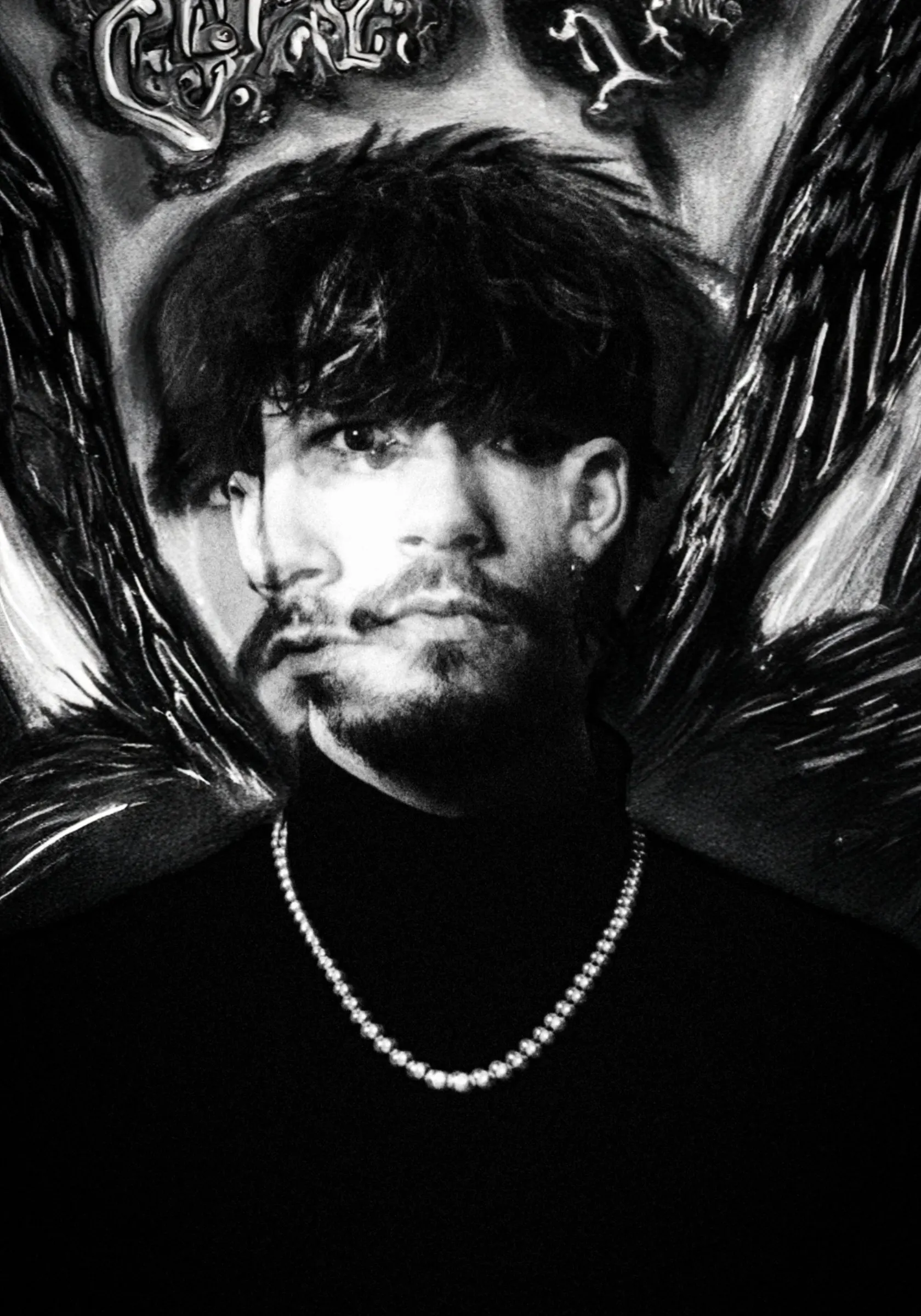 Black and white portrait of a young man with dark hair, a beard and a pearl necklace in front of a painted backdrop with wings, a haunting double image across his face
